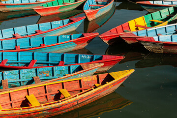 Fototapeta na wymiar Close-up of multicoloured tourist boats in Phewa lake, Pokhara, Nepal