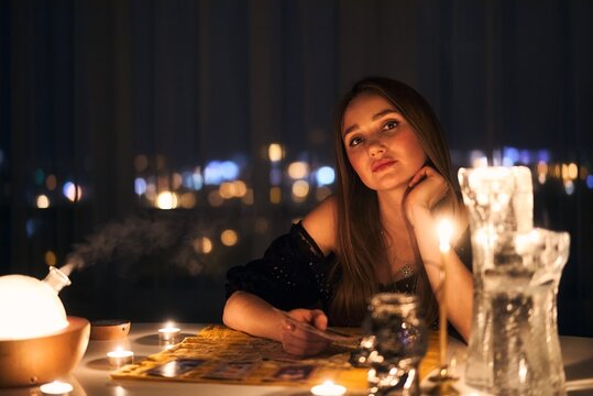 Woman Reading Tarot Cards In Spiritual Room