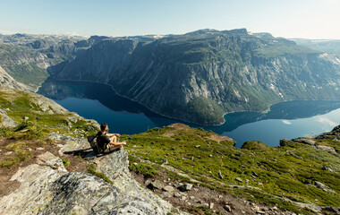 A young man looks at the stunning landscape of mountains, Vestland county, Norway