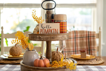 Dining room table decorated for fall with mini pumpkins and a cute sign that says hello pumpkin