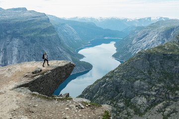 A young woman walk on Trolltunga cliff, Vestland county, Norway