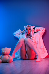 sexy young girl in a cute hoodie with ears in underwear on the floor with a teddy bear