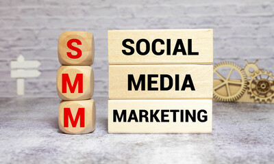 SMM - social media marketing - letters on wooden cubes on grey blue background