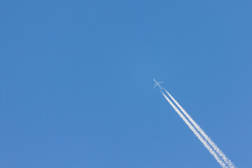 Flying plane leaves an inversion trail in the air. White and blue . nice logo