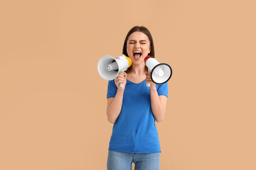 Protesting young woman with megaphones on color background