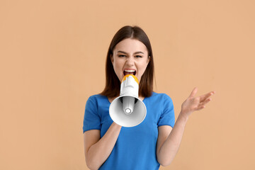 Protesting young woman with megaphone on color background