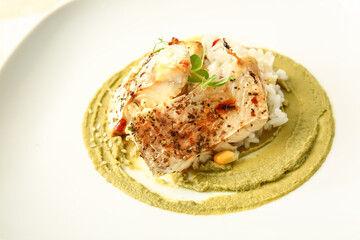 Plate with tasty baked cod fillet, rice and guacamole sauce, closeup