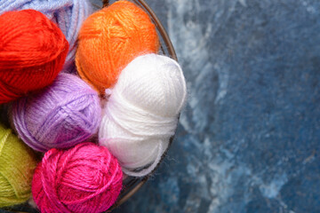 Basket with knitting yarn on color background, closeup