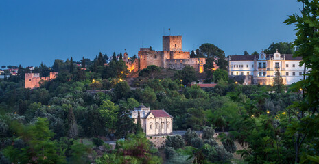 Fototapeta na wymiar Panoramic view at dusk of the monumental complex of Tomar Castle, Convent of Christ and the Chapel of Nossa Senhora da Conceição, in the city of Tomar, Portugal.