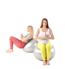 Fototapeta na wymiar Young pregnant women with fitball practicing yoga on white background