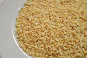 Food crumbs - Cloeup of some small pieces of almonds in a plate looking like cheese - Cereals, Dried fruits and Nuts
