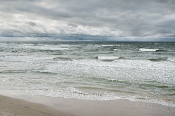 Baltic sea during the storm. Dramatic sky, dark glowing clouds. Waves, water splashes. Idyllic...