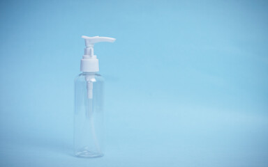 Transparent antibacterial gel dispenser on isolated blue background. Copy space.
