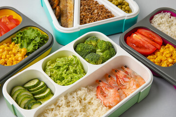 Containers with different healthy food on grey table, closeup