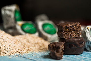 Close up view of Argentine homemade alfajores dipped in black chocolate, broken and showing chocolate inside