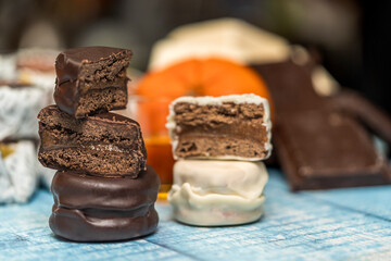Close up view of Argentine homemade alfajores dipped in white chocolate and black chocolate, broken...