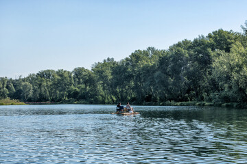 Fototapeta na wymiar People having rest, tanning, swimming, using a catamaran on a lake in summer.