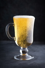 A glass of light beer in the sun. Ideal for beer marketing and advertising with space for text. Pouring beer.
