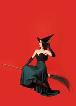 Young witch with broom on color background