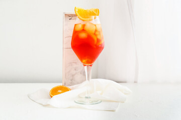 Glass of Aperol spritz cocktail on light background