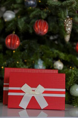 Christmas presents.Surprises and gifts for the winter holidays. Red gift boxes on Christmas tree background.Christmas and New Years.Merry Christmas.