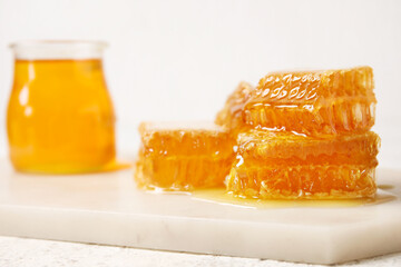Board with honey combs on white background