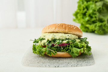 Board with tasty vegetarian burger on table