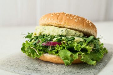 Board with tasty vegetarian burger on table
