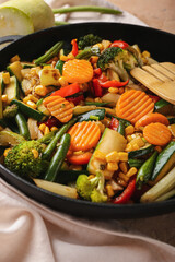 Frying pan with different vegetables on table, closeup