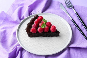 Plate with piece of tasty raspberry pie and mint on fabric background, closeup