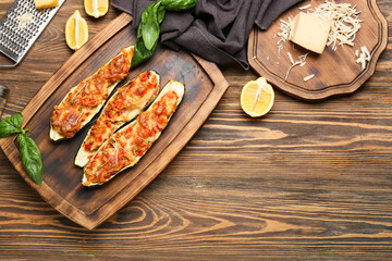 Composition with meat stuffed zucchini boats on wooden background