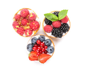 Tasty berry tartlets on white background