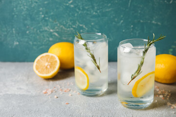 Glasses of cold gin tonic on color background
