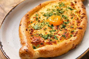Plate with tasty Ajarian khachapuri on table, closeup