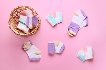 Wicker basket and different socks on color background