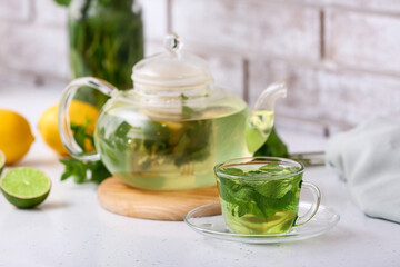 Glass cup of tasty mint tea on table, closeup
