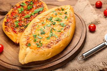 Board with delicious Turkish Pide Pizza on wooden background