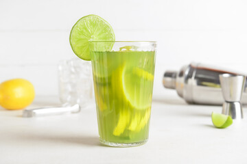 Glass with tasty lemonade on light background