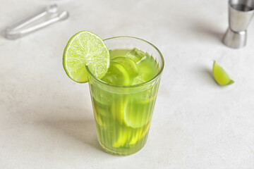 Glass with tasty lemonade on light background
