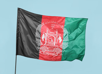 Waving flag of Afghanistan on blue background
