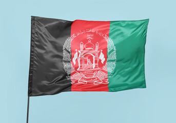 Waving flag of Afghanistan on blue background
