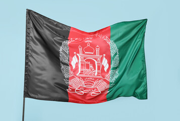 Waving flag of Afghanistan on blue background