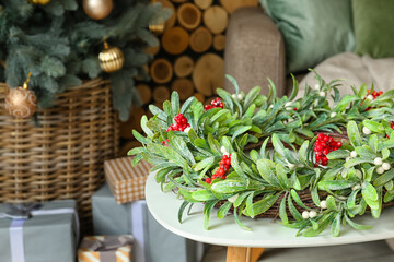 Christmas mistletoe wreath on table in room
