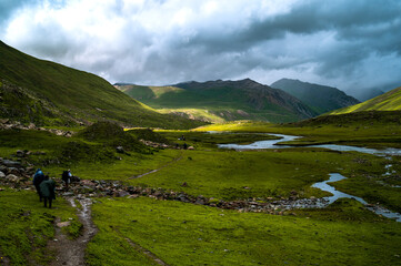 Landscape with sky and clouds. Serine green meadow landscape high up in the Himalayas on Great Lake of Kashmir trek. valley. Mountains in Gangabal Lake vicinity, Kashmir India © Kunal