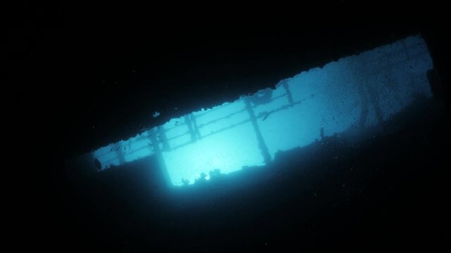 Unique FPV looking up at the sunlight deep inside a underwater shipwreck.
