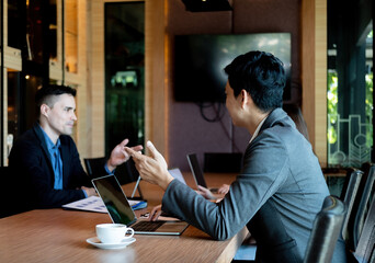 A group of business people are meeting to analyze data for marketing plan at meeting room