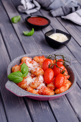Gnocchi with tomatoes, red sauce, cheese and basil leaves