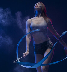 Woman exercising with ribbon in dust cloud view
