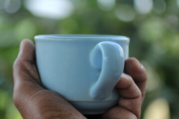 Close up the cup of coffee in hand