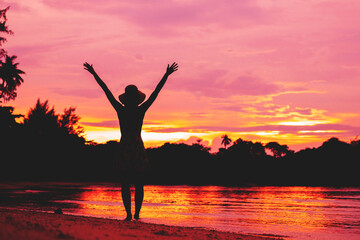 Free happy woman raising arms watching the sunset